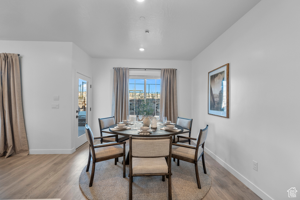 Dining space with light wood finished floors, baseboards, and recessed lighting
