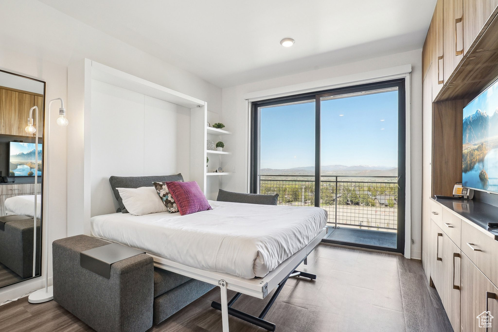 Bedroom featuring access to outside, multiple windows, and dark wood-type flooring