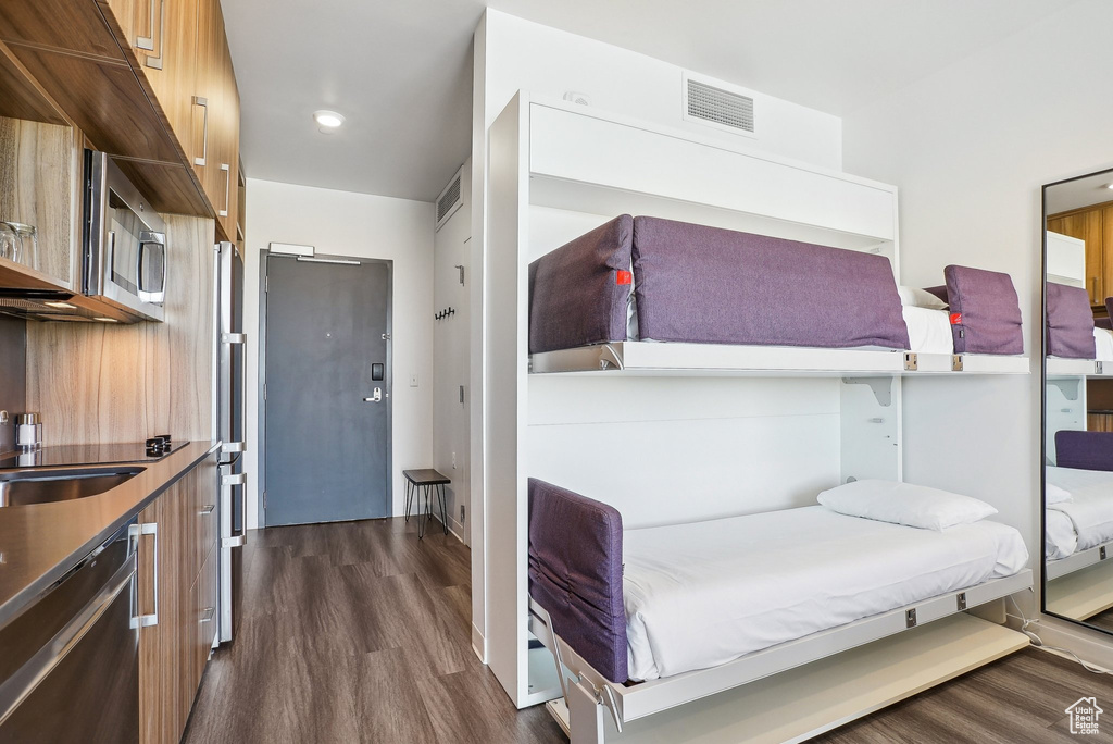 Bedroom with dark wood-type flooring and a sink