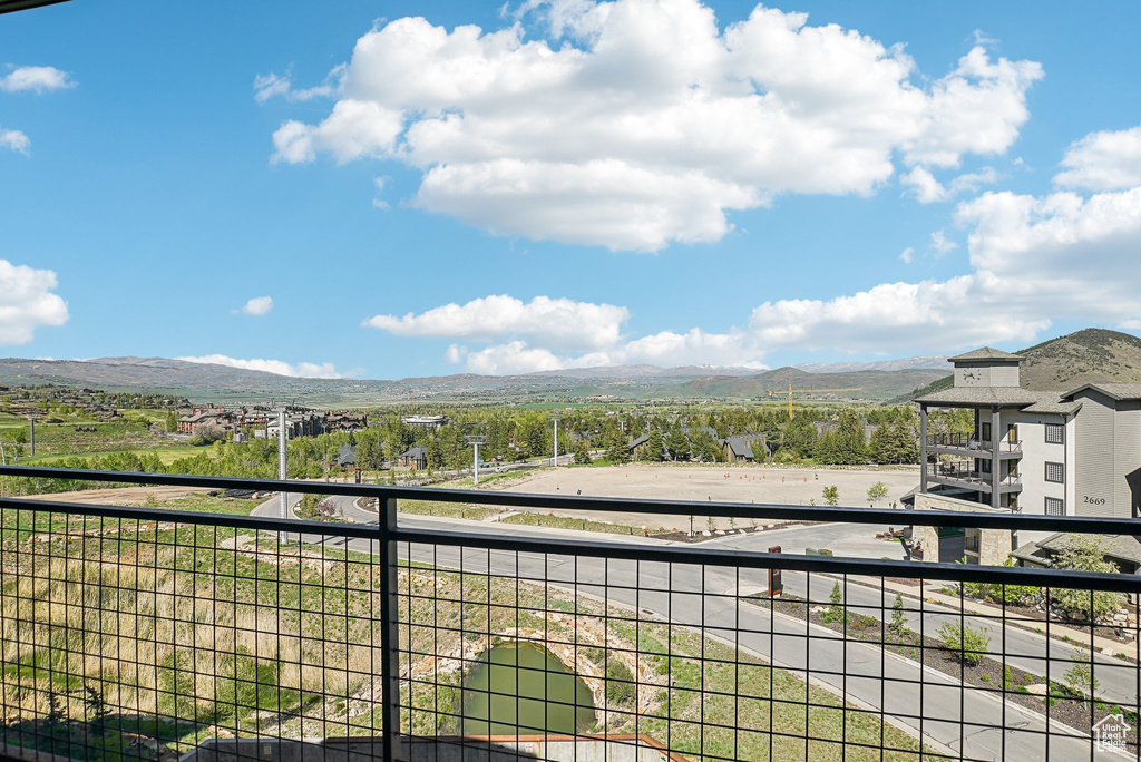 View of yard with a balcony and a mountain view