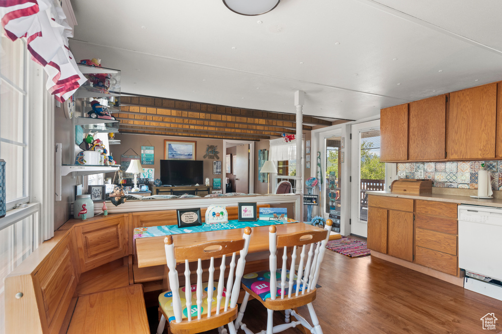 Kitchen with dishwasher, decorative backsplash, light countertops, light wood-type flooring, and brown cabinets