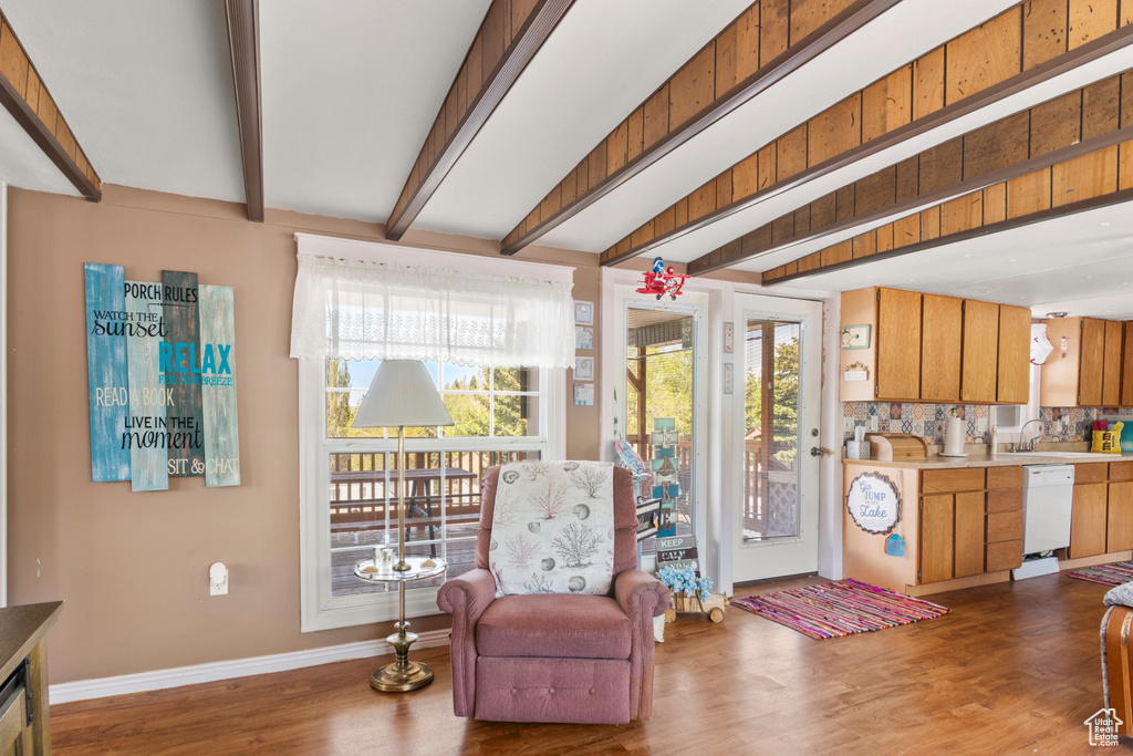 Living area with baseboards, wood finished floors, and beamed ceiling
