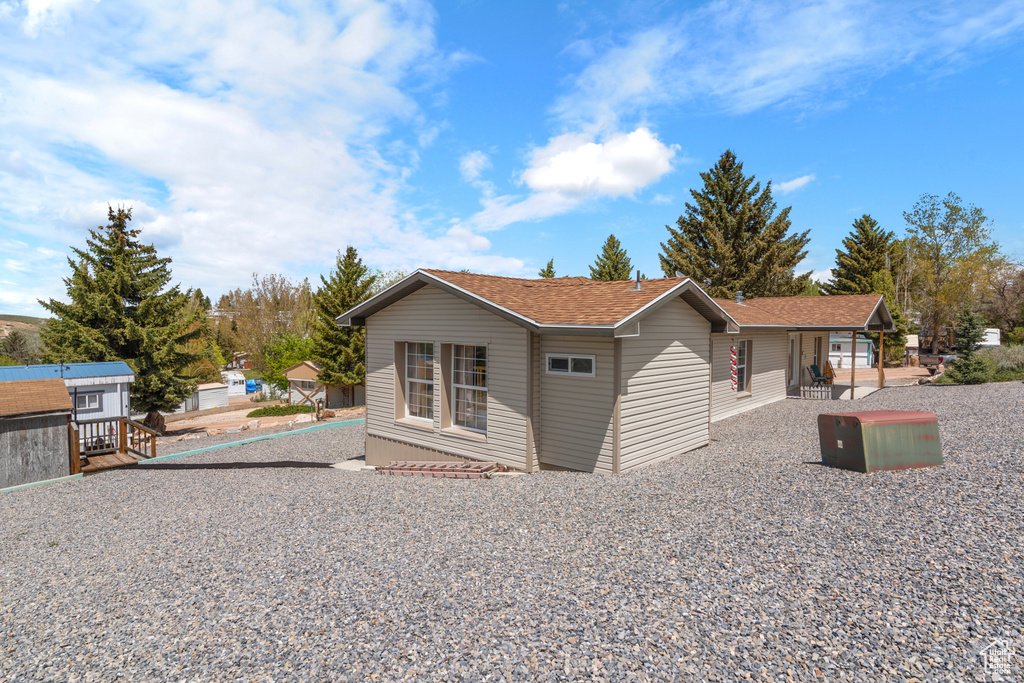 View of side of property featuring a shingled roof