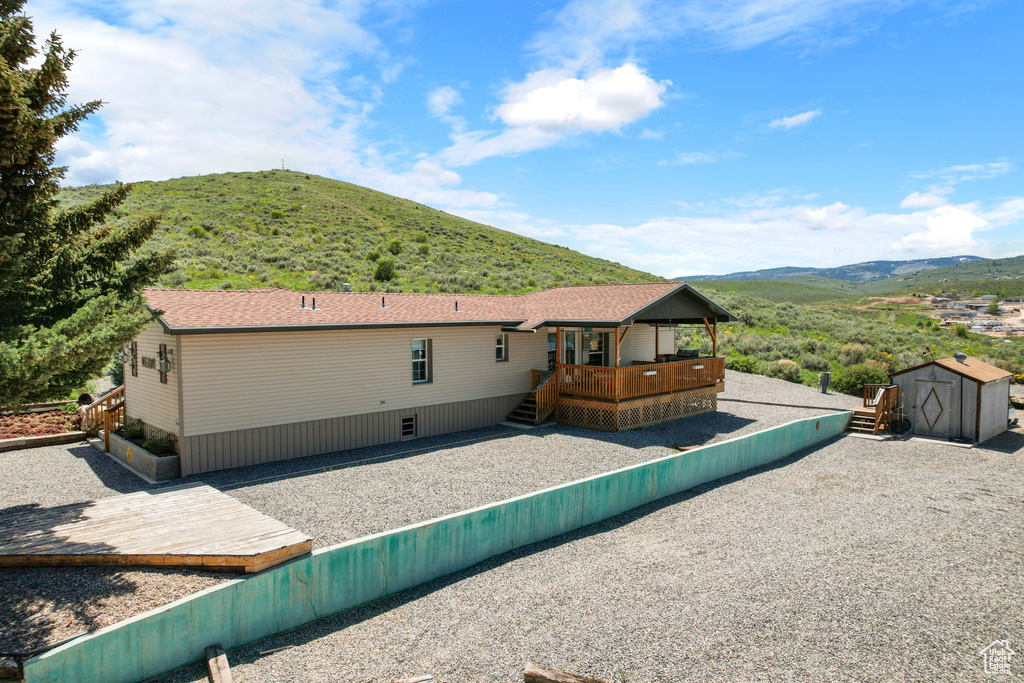 Rear view of property with a deck with mountain view