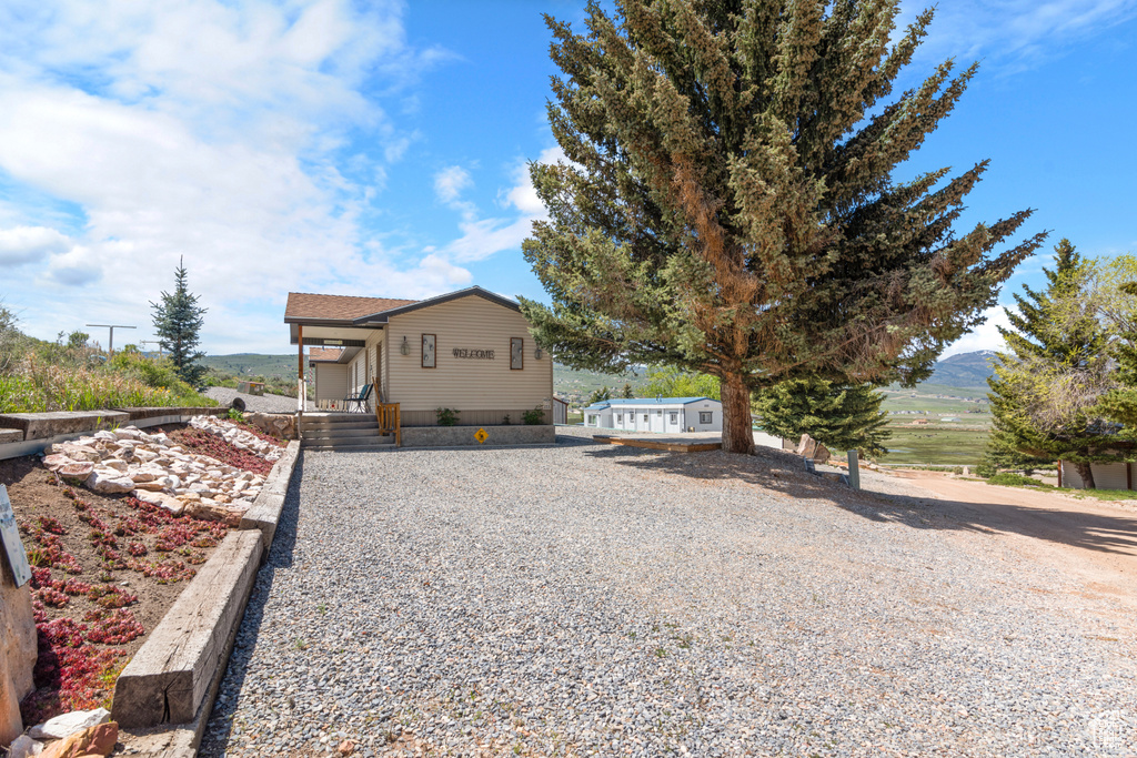 View of front of property with driveway and a mountain view
