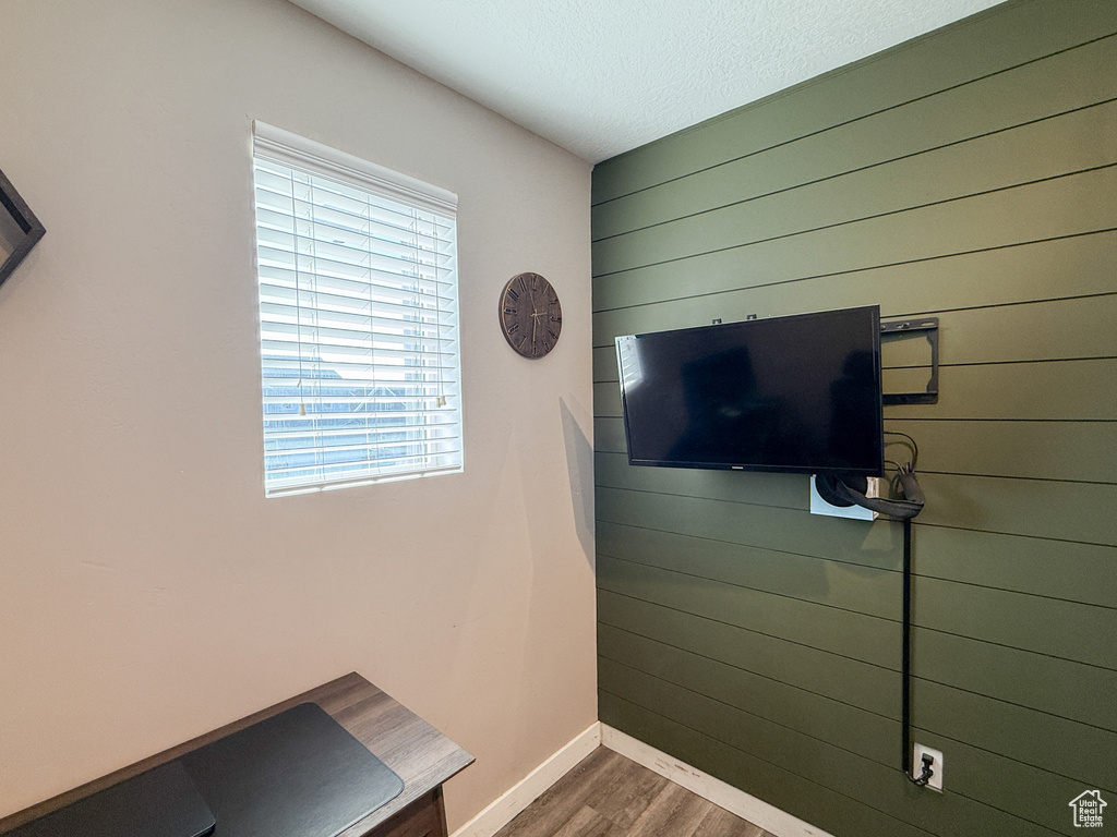 Detailed view of wooden walls, wood finished floors, baseboards, and a textured ceiling