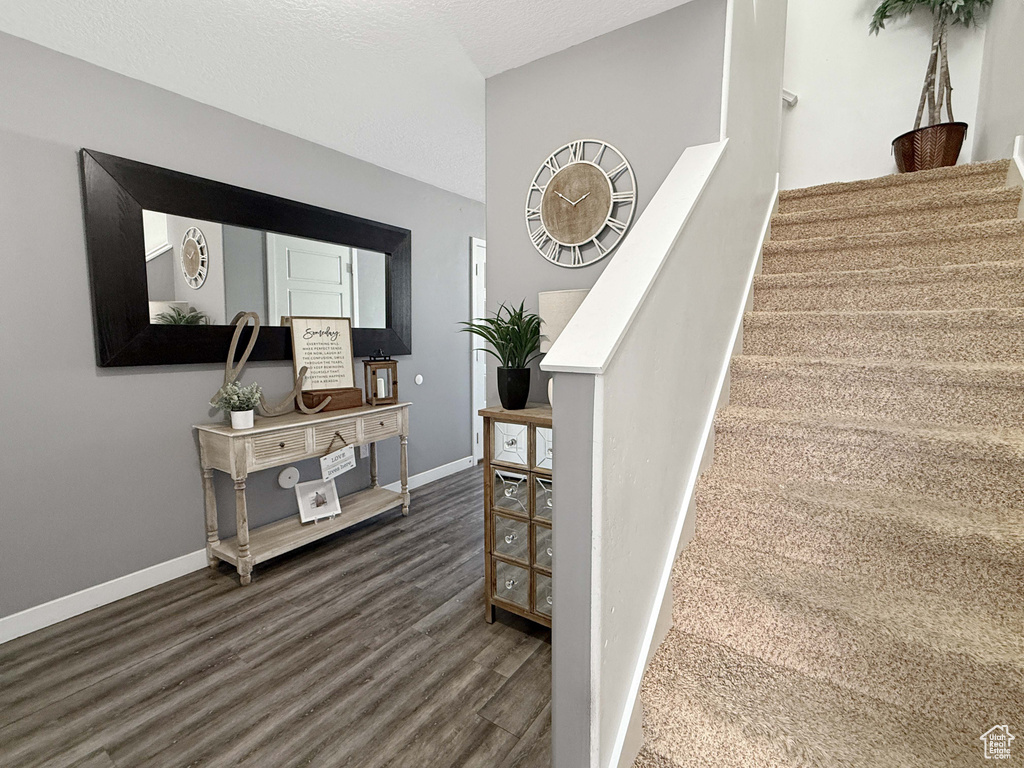 Staircase with wood finished floors and baseboards