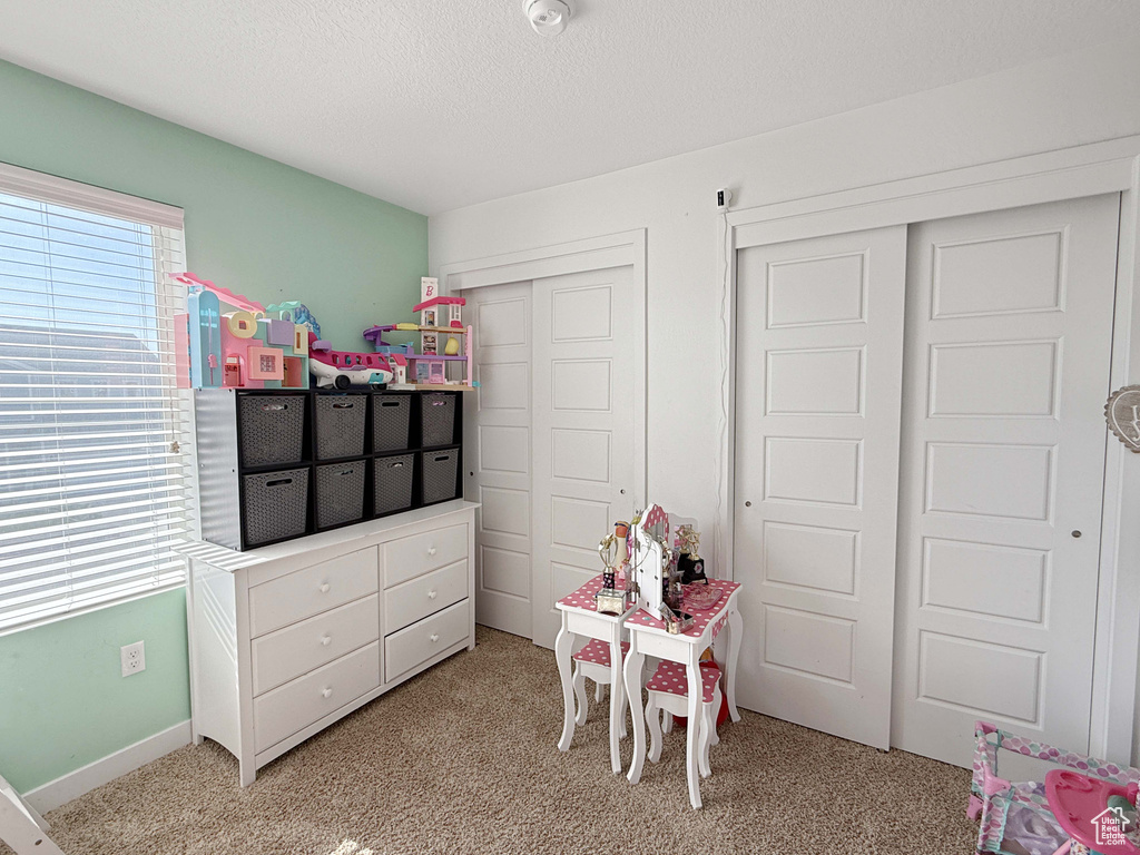 Playroom with light carpet and a textured ceiling