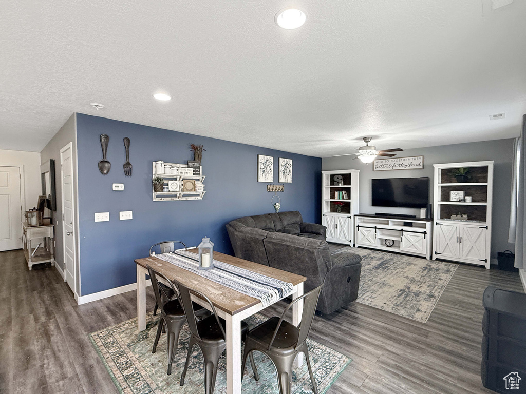 Dining space featuring ceiling fan, dark wood finished floors, a textured ceiling, baseboards, and recessed lighting
