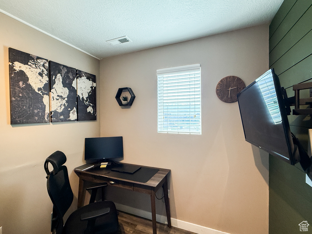 Home office with wood finished floors and a textured ceiling