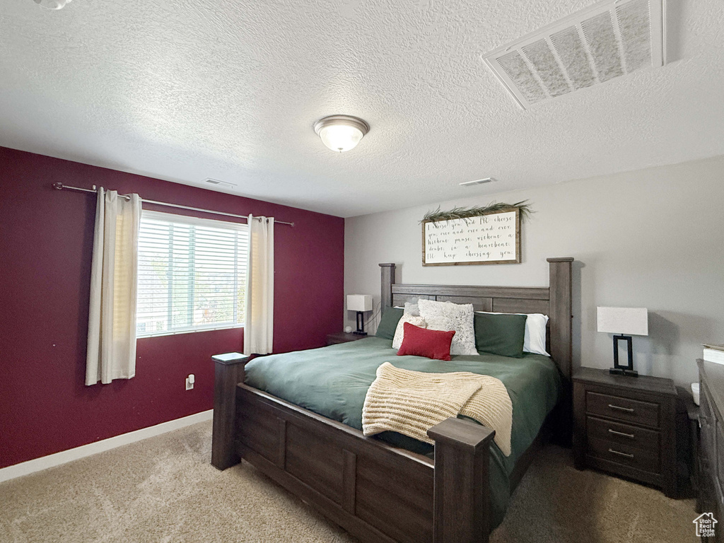 Bedroom with carpet floors, a textured ceiling, and baseboards