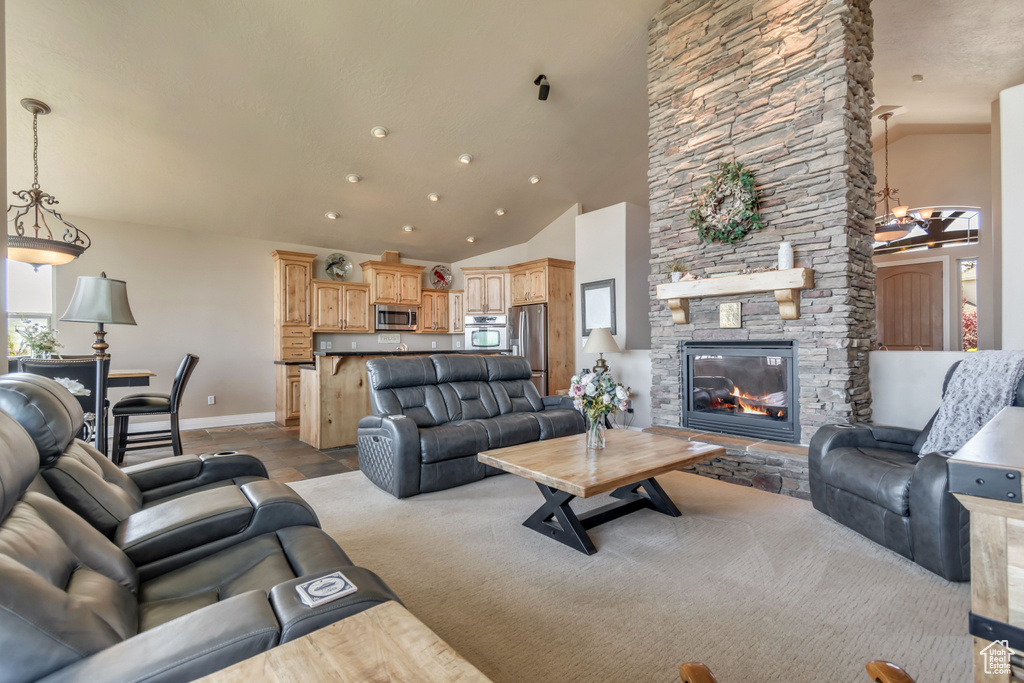 Living area featuring baseboards, a fireplace, and high vaulted ceiling