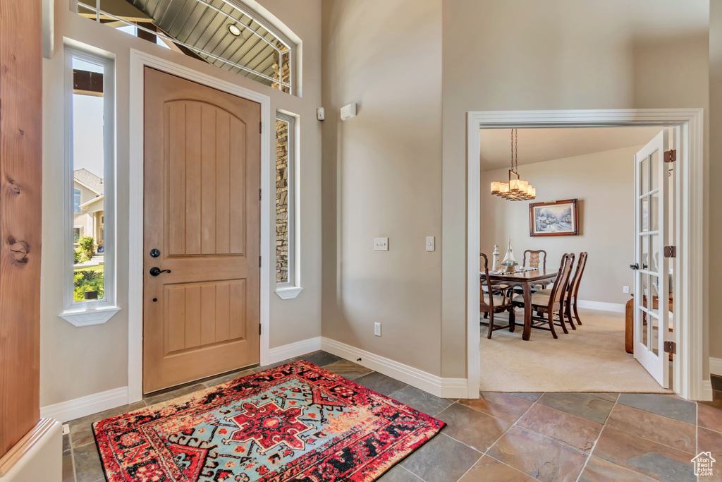 Entrance foyer with a chandelier and baseboards