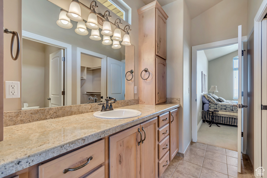 Bathroom featuring vanity, toilet, tile patterned flooring, and baseboards