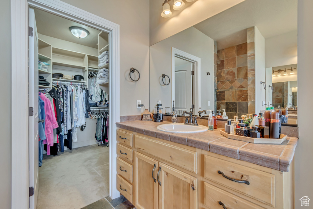 Full bathroom featuring vanity and a walk in closet