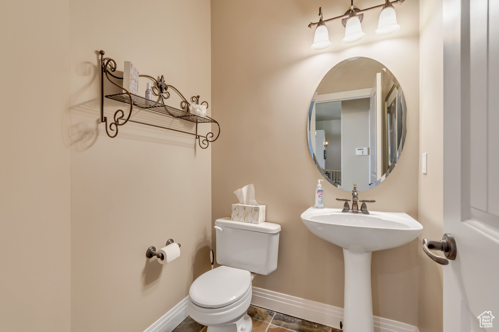 Bathroom with baseboards, toilet, and a sink