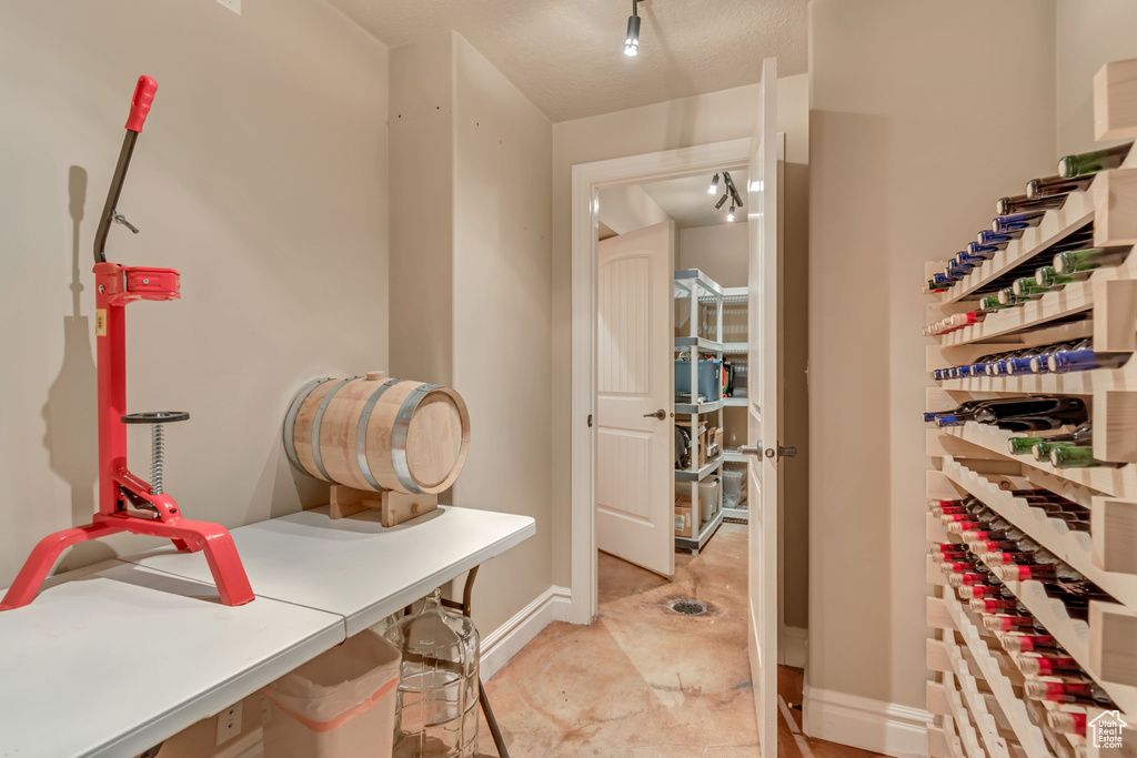 Wine room featuring baseboards and rail lighting