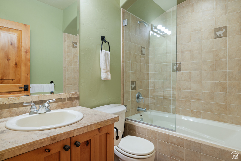 Bathroom with toilet, tiled shower / bath, and vanity