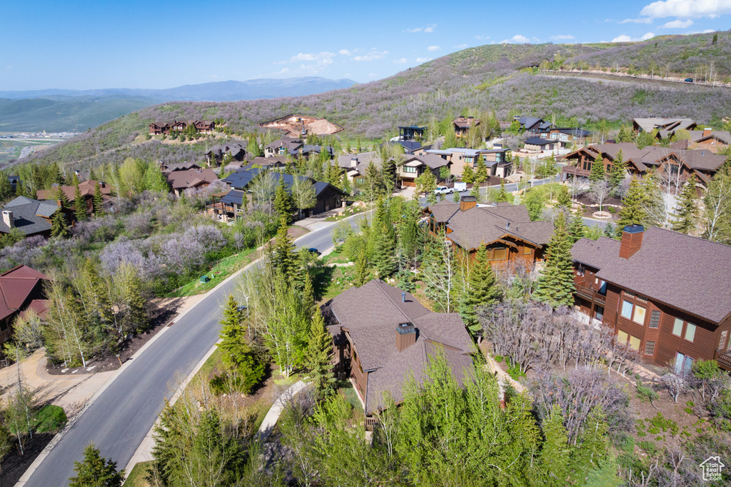Aerial view of property and surrounding area featuring nearby suburban area and mountains