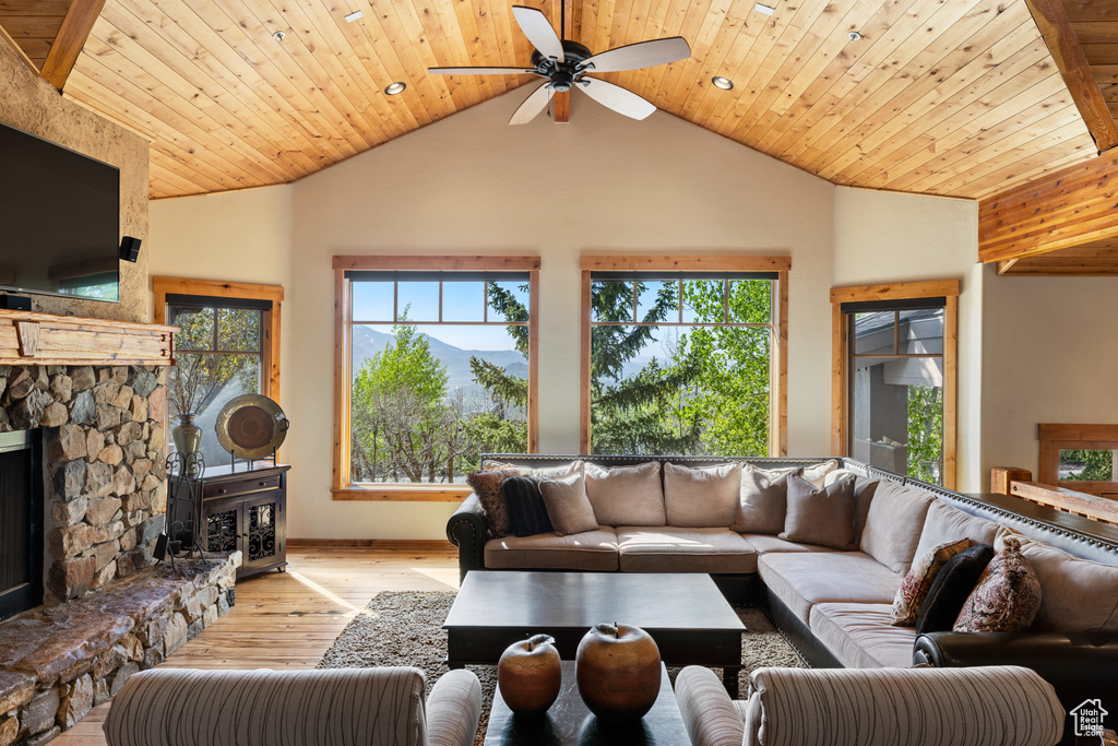 Living area with hardwood / wood-style flooring, vaulted ceiling, a ceiling fan, wooden ceiling, and baseboards