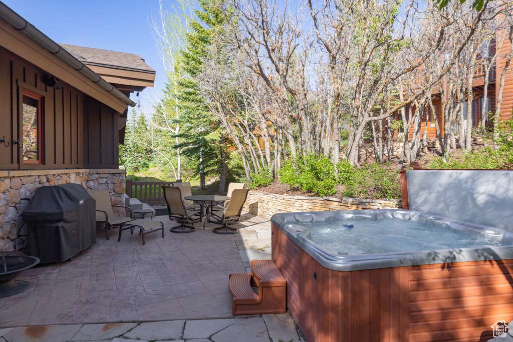 View of patio / terrace with a hot tub, grilling area, and outdoor dining space