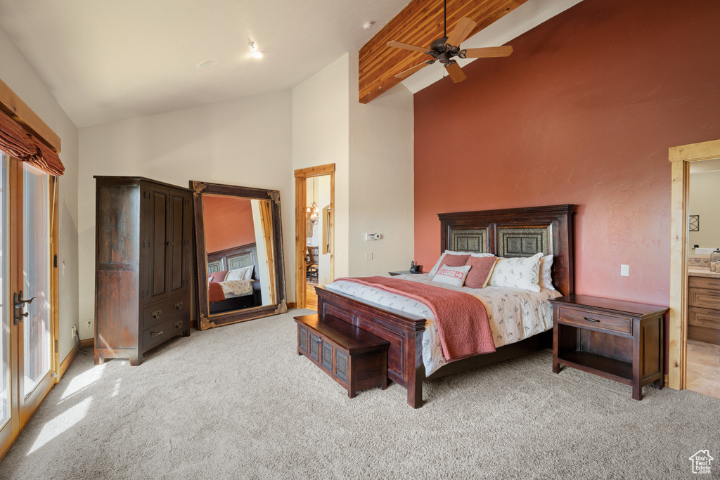 Bedroom with carpet floors, high vaulted ceiling, a ceiling fan, connected bathroom, and beamed ceiling