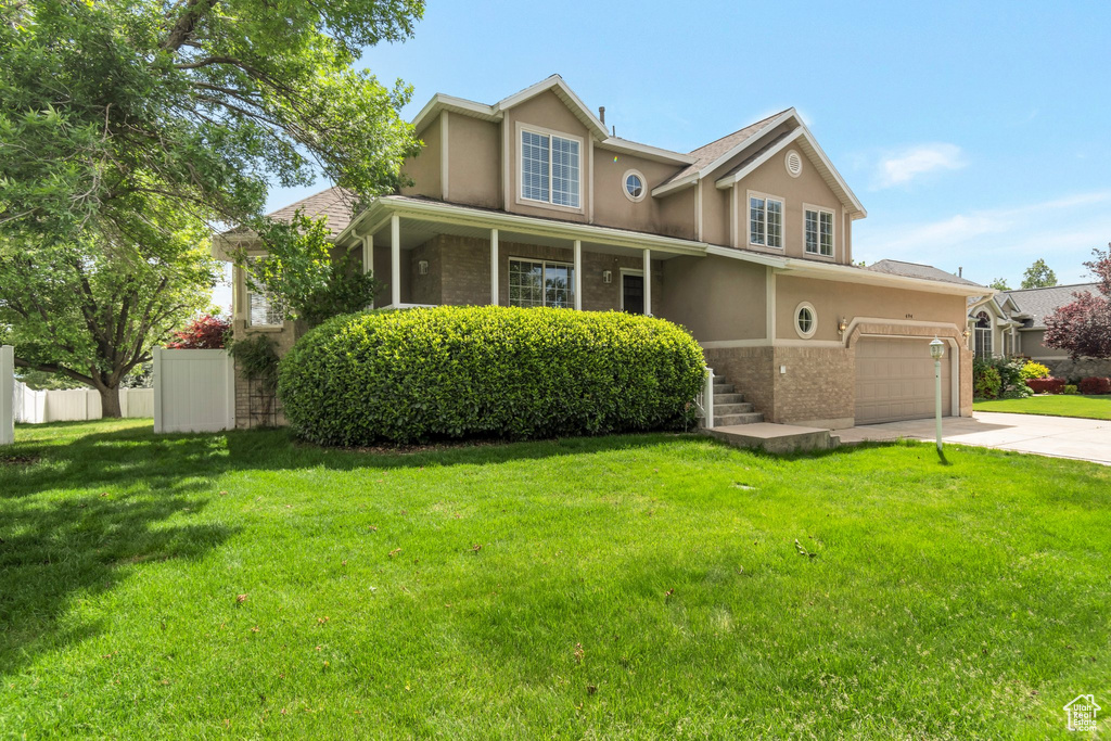 Traditional-style house with concrete driveway, stucco siding, and brick siding