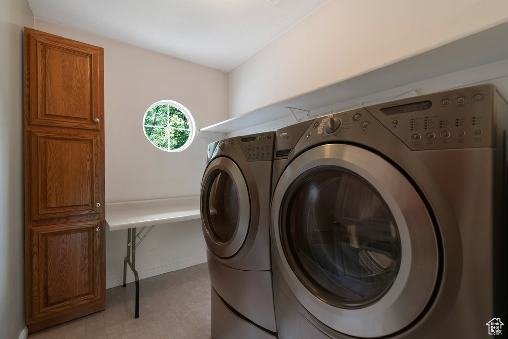 Laundry area with independent washer and dryer and baseboards