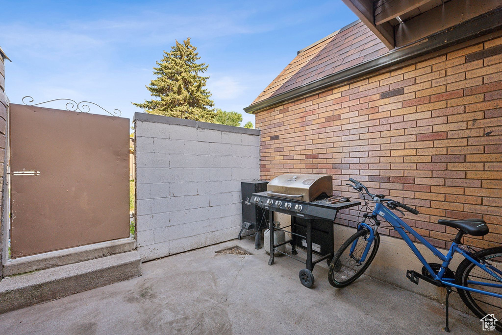 View of patio with a grill