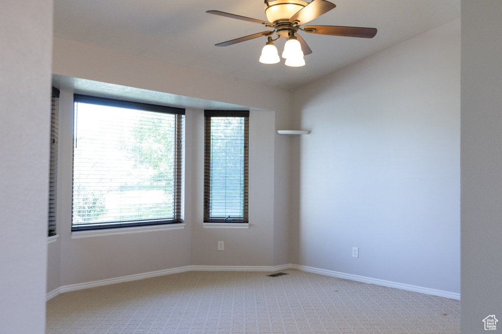 Spare room with light carpet, healthy amount of natural light, and vaulted ceiling