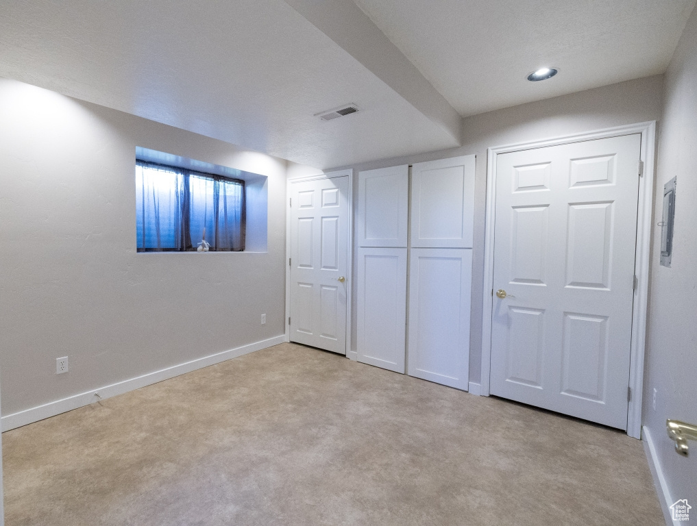 Basement featuring light carpet and baseboards