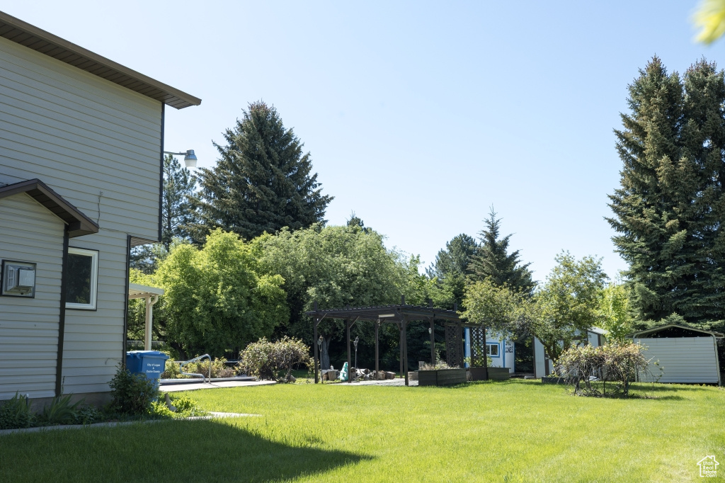View of grassy yard featuring a pergola