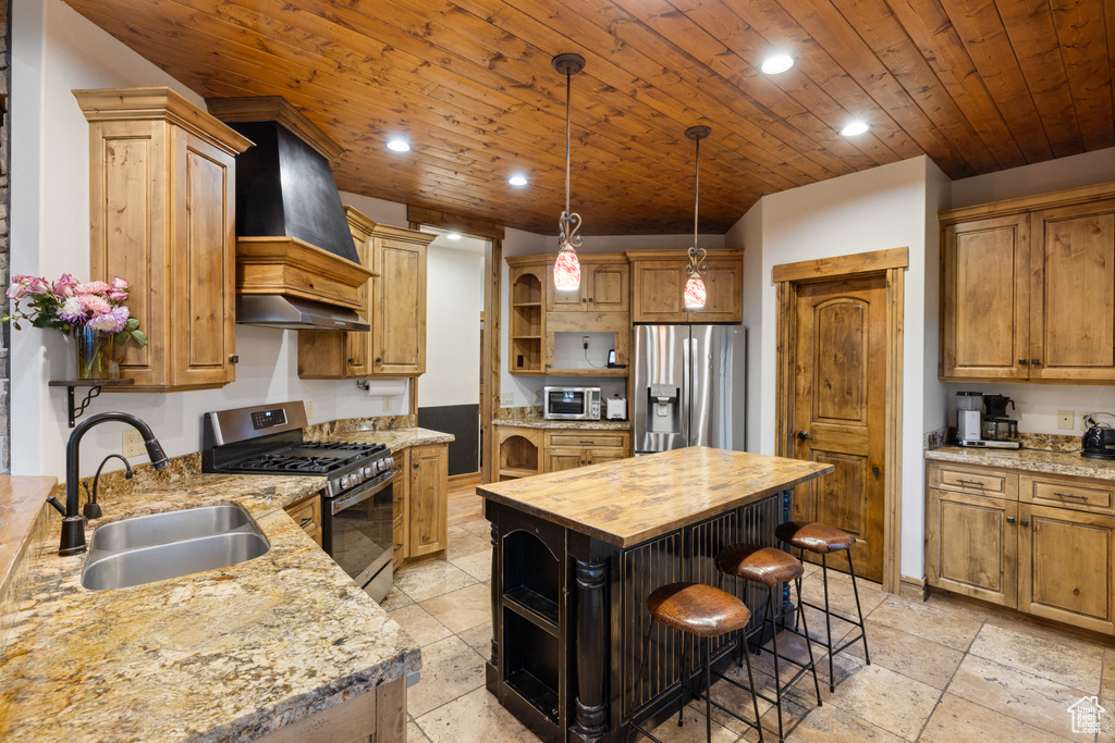 Kitchen featuring appliances with stainless steel finishes, open shelves, custom range hood, a sink, and wooden counters