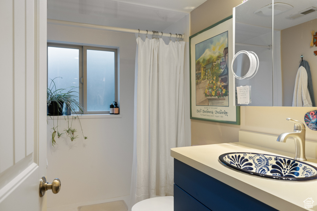Bathroom featuring vanity, toilet, and a shower with shower curtain