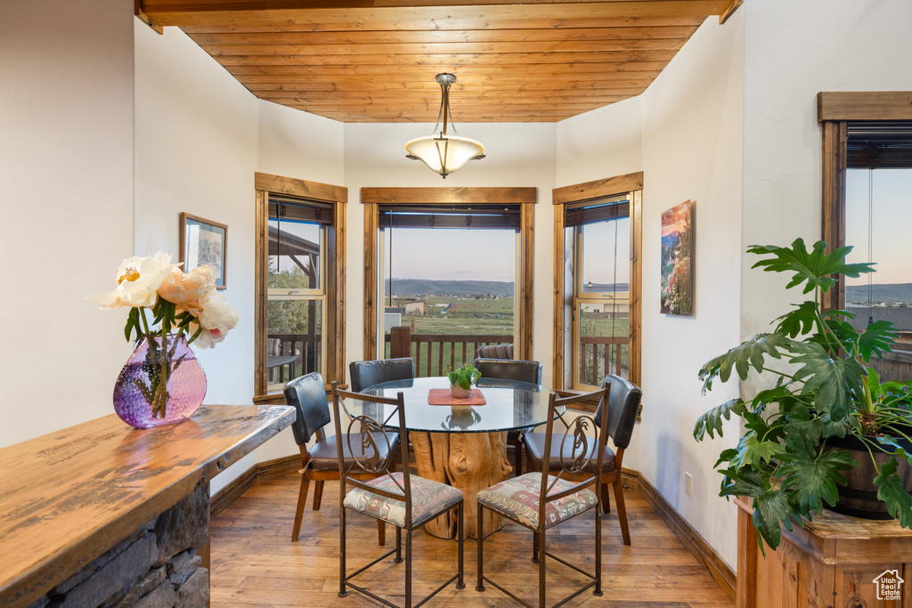 Dining room featuring wood-type flooring, wood ceiling, and baseboards