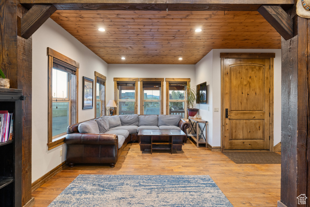 Living room featuring light wood-style flooring, recessed lighting, wood ceiling, and baseboards