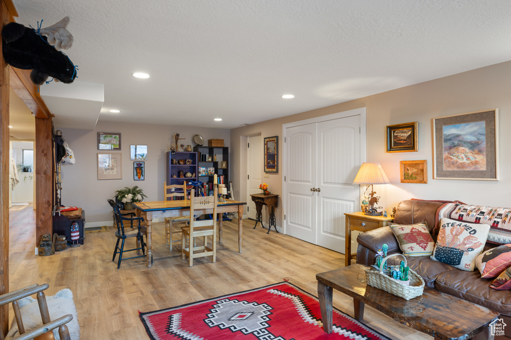 Living room with light wood-style flooring, recessed lighting, and baseboards