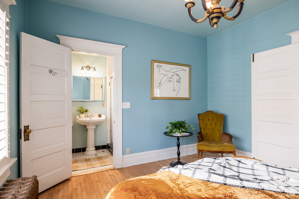 Living area with hardwood / wood-style floors, a chandelier, and baseboards