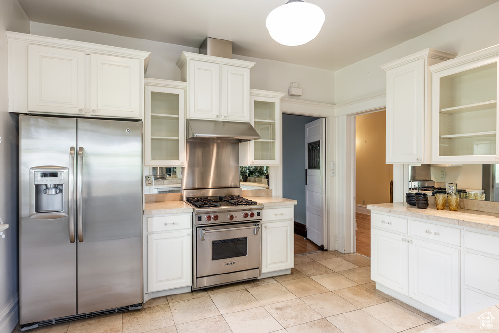 Kitchen featuring stainless steel appliances, under cabinet range hood, white cabinets, and glass insert cabinets