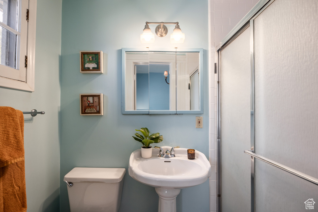 Bathroom featuring toilet and a shower with door