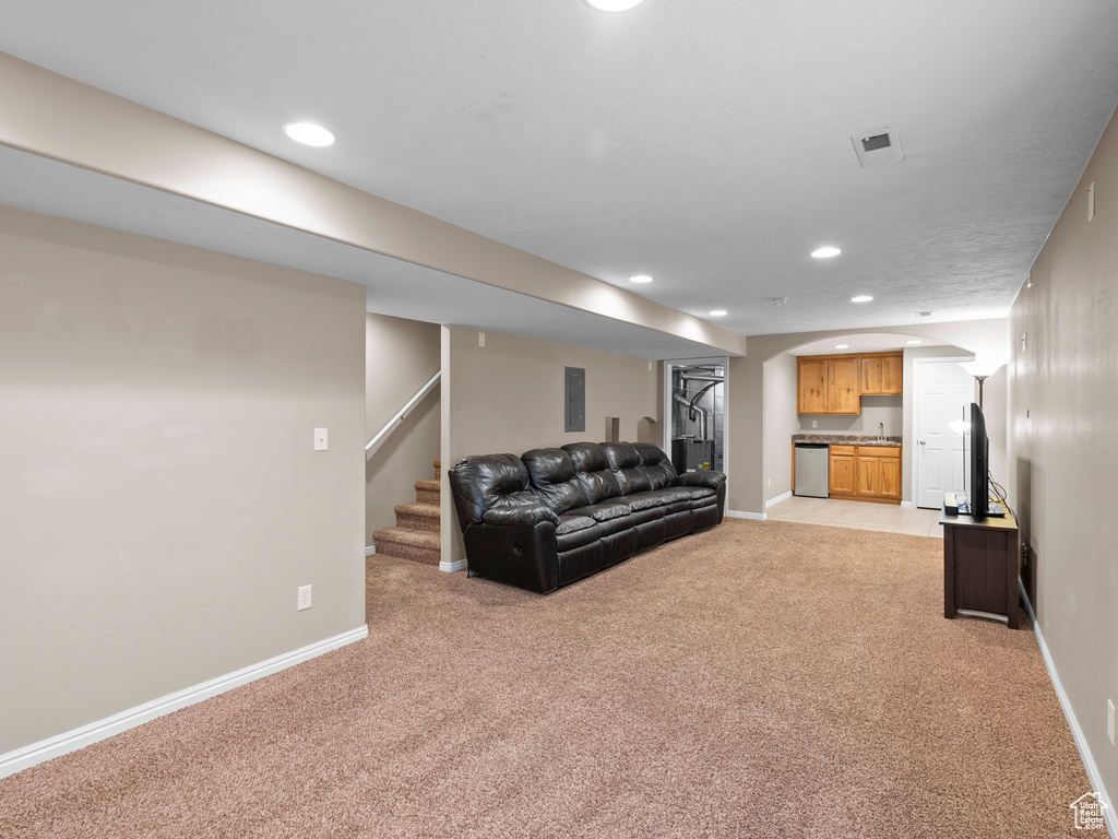 Living area featuring light carpet, recessed lighting, baseboards, arched walkways, and stairway