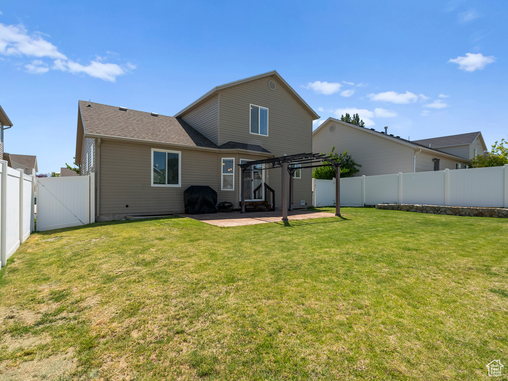 Back of house featuring a patio, a pergola, and a gate