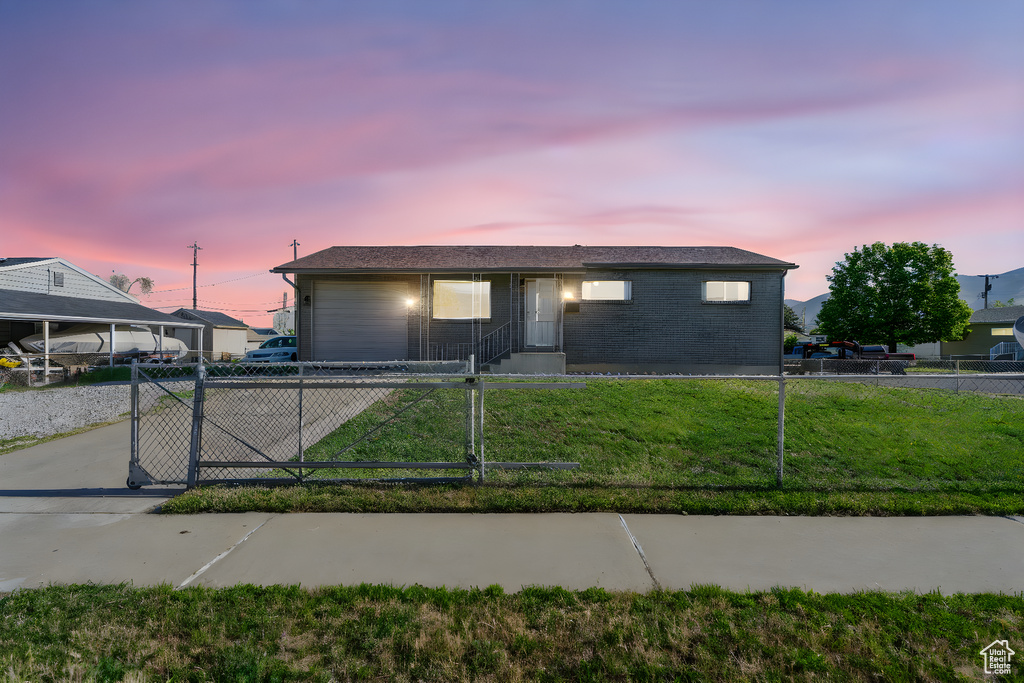 Single story home featuring driveway, a garage, a gate, and brick siding