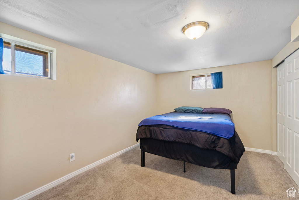 Carpeted bedroom featuring baseboards and a closet