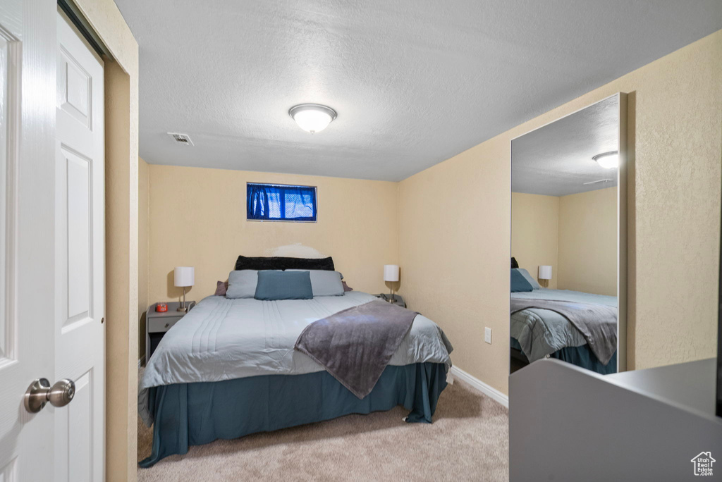 Carpeted bedroom featuring a textured ceiling