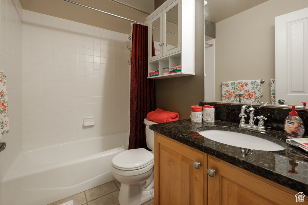 Bathroom featuring vanity, tile patterned floors, shower / tub combo with curtain, and toilet