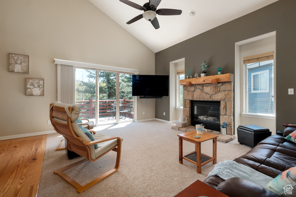 Living room featuring high vaulted ceiling, a ceiling fan, baseboards, and a fireplace
