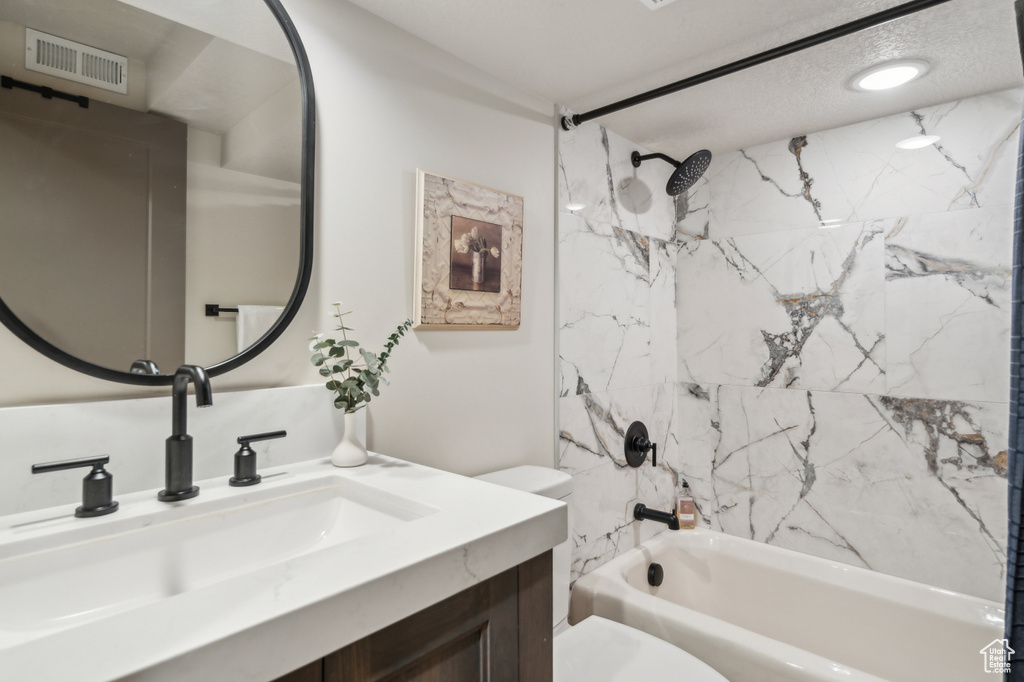 Full bathroom with toilet, shower / bath combination, and vanity