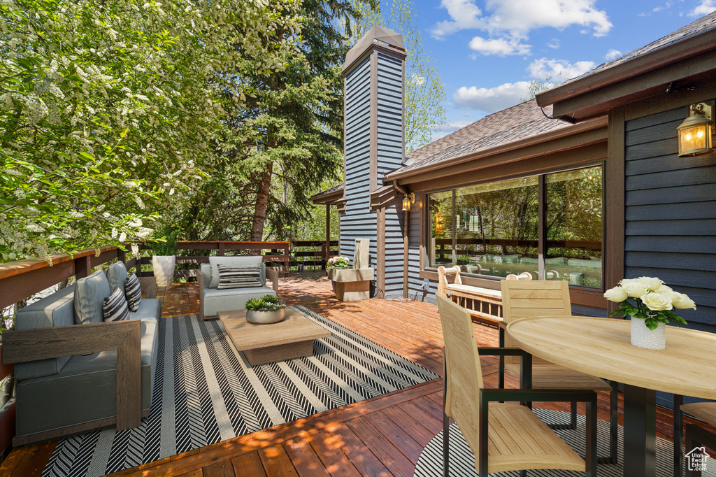 Wooden terrace featuring outdoor lounge area and outdoor dining space