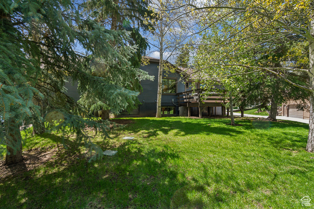 View of green lawn featuring a deck